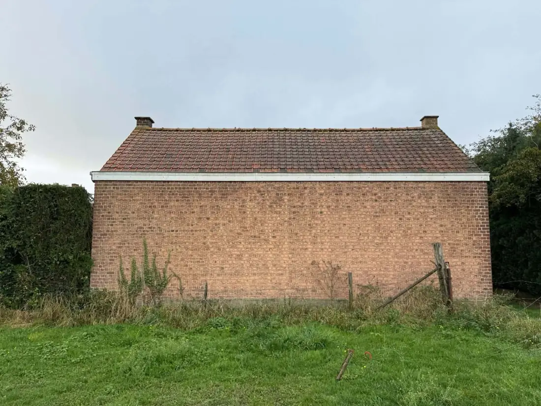 Avant travaux : ancienne toiture en tuiles sur un bâtiment en briques