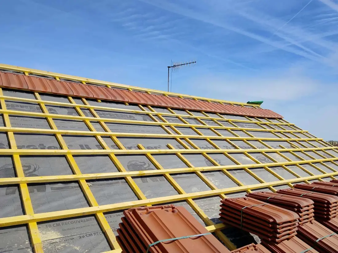 Liteaux posés sur écran de sous-toiture et palettes de tuiles neuves