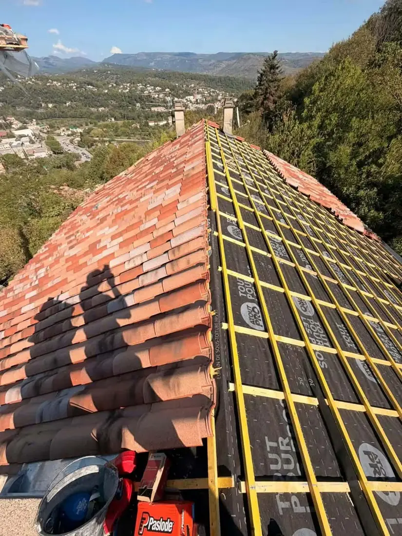 Toiture en cours de réfection avec liteaux et tuiles rouges